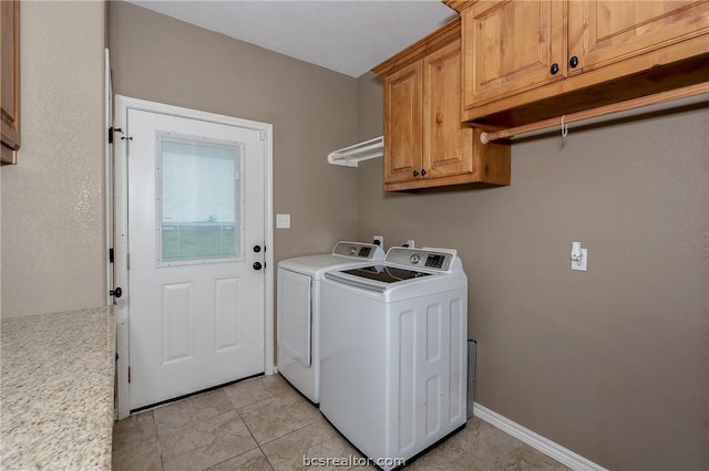 laundry room with cabinets, light tile patterned floors, and washer and clothes dryer