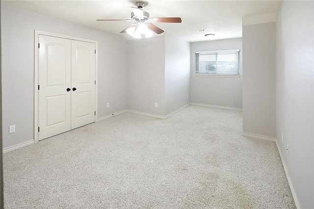 unfurnished bedroom with ceiling fan and a closet