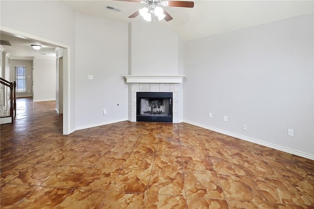 unfurnished living room featuring a tile fireplace, vaulted ceiling, and ceiling fan