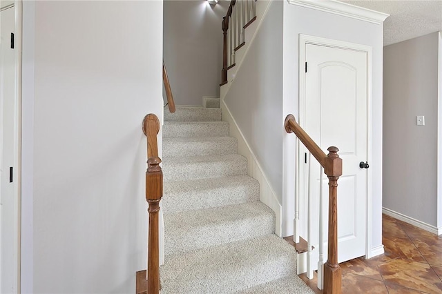 staircase featuring a textured ceiling