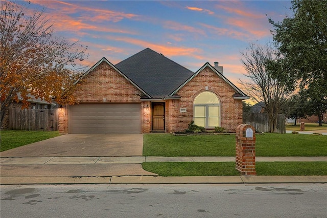 view of front property featuring a garage and a yard