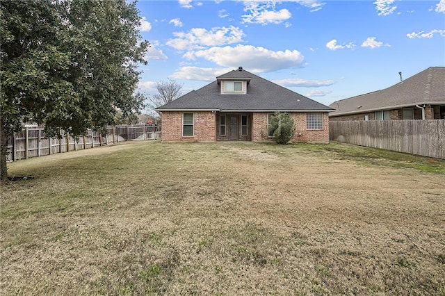 rear view of house featuring a lawn