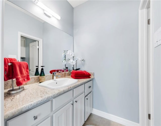 bathroom with baseboards, tile patterned flooring, and vanity