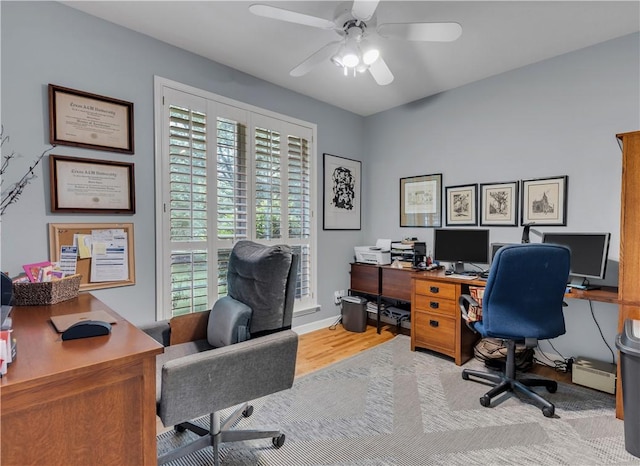 office with a ceiling fan, baseboards, and wood finished floors