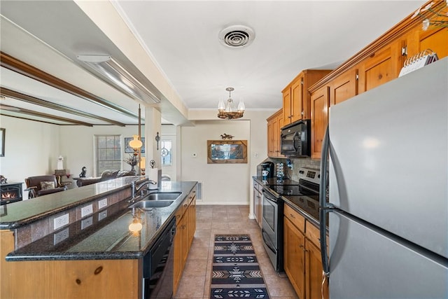 kitchen with black appliances, sink, ornamental molding, an island with sink, and tasteful backsplash