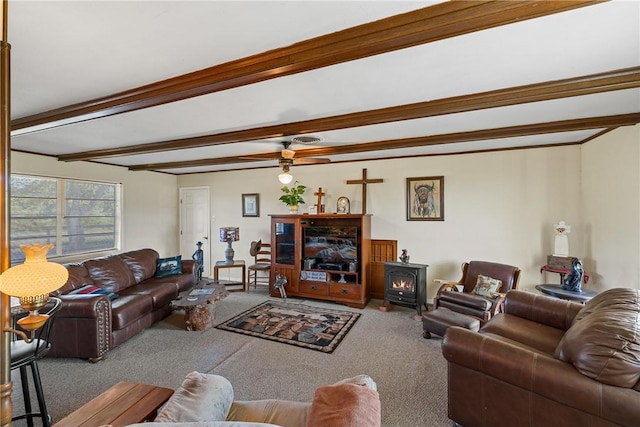 living room featuring carpet, beam ceiling, a wood stove, and ceiling fan