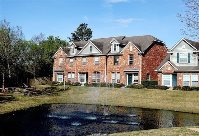 view of front of property featuring a water view and a front lawn