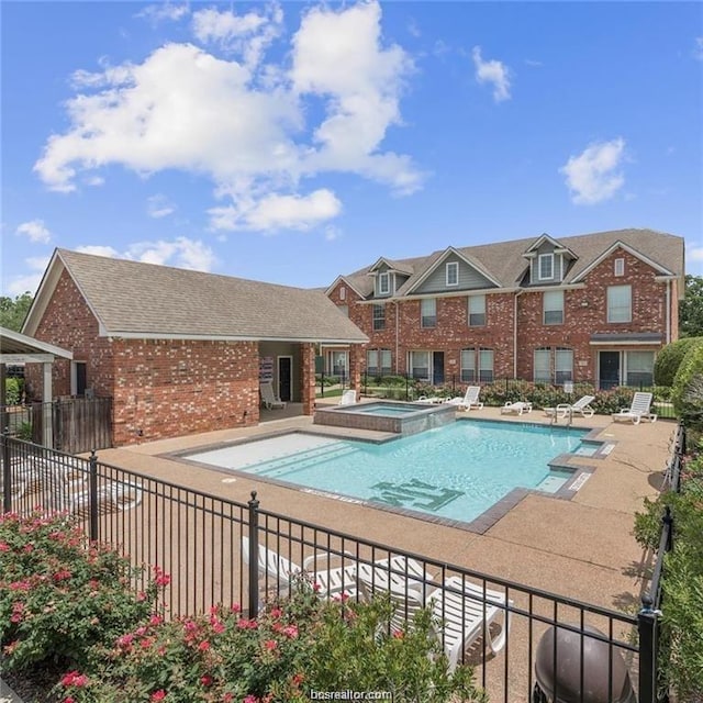 view of pool with a patio area and a hot tub