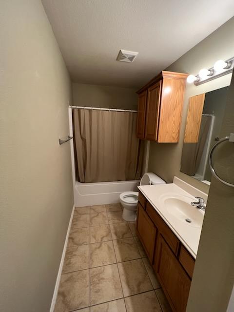 full bathroom featuring vanity, toilet, tile patterned floors, and shower / bath combo with shower curtain