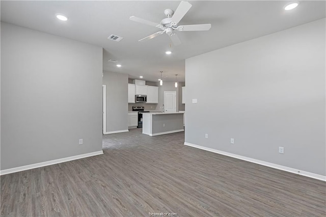 unfurnished living room featuring ceiling fan and dark wood-type flooring