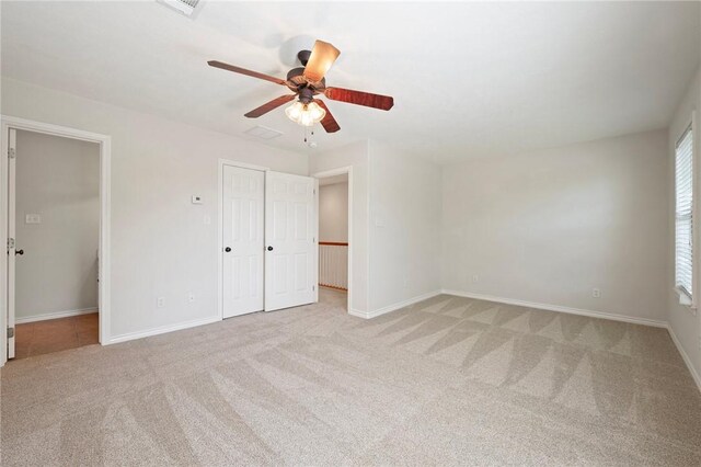 unfurnished bedroom with a closet, baseboards, carpet flooring, and ceiling fan