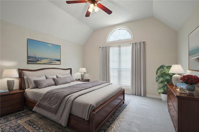 bedroom featuring light colored carpet, baseboards, a ceiling fan, and lofted ceiling