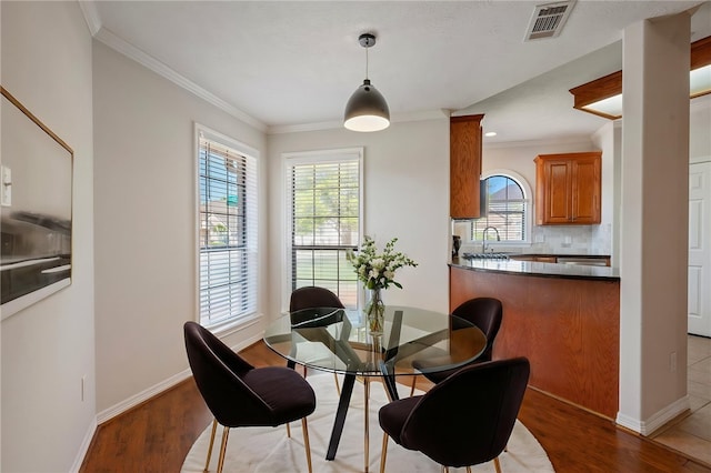 dining space with visible vents, a wealth of natural light, and wood finished floors