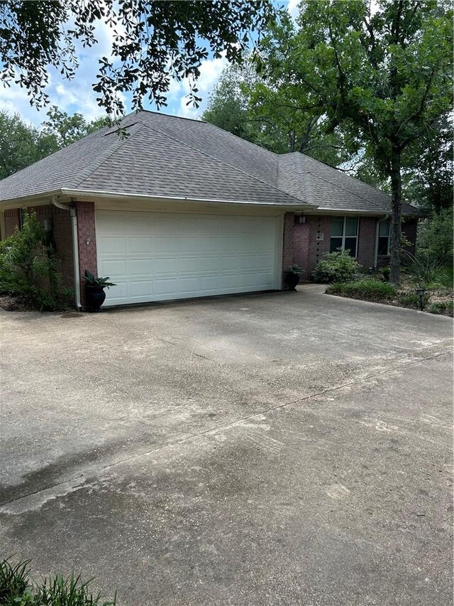 2020 Carter Lake Dr, College Station, TX 77845 - view of front facade with an attached garage, brick siding, a shingled roof, and concrete driveway