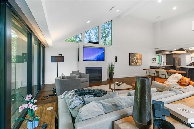 23 Forest Dr, College Station, TX 77840 - living area featuring wood finished floors, high vaulted ceiling, baseboards, a glass covered fireplace, and beam ceiling