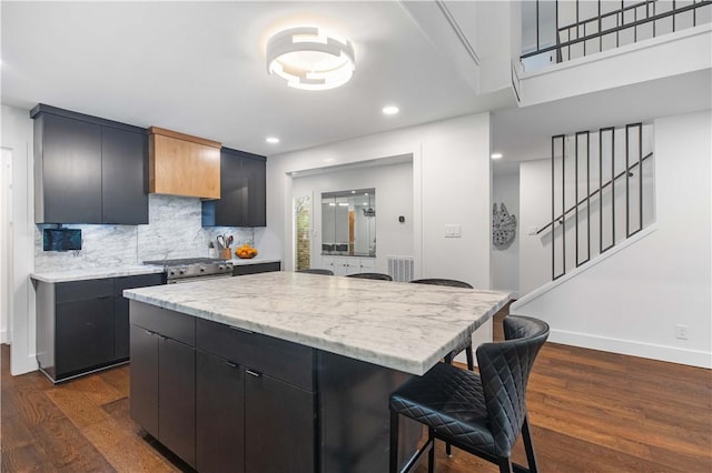 23 Forest Dr, College Station, TX 77840 - kitchen with a breakfast bar, dark wood-style floors, dark cabinetry, a kitchen island, and recessed lighting