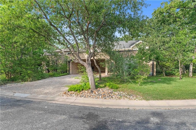 23 Forest Dr, College Station, TX 77840 - view of property hidden behind natural elements featuring driveway, a front yard, and a garage