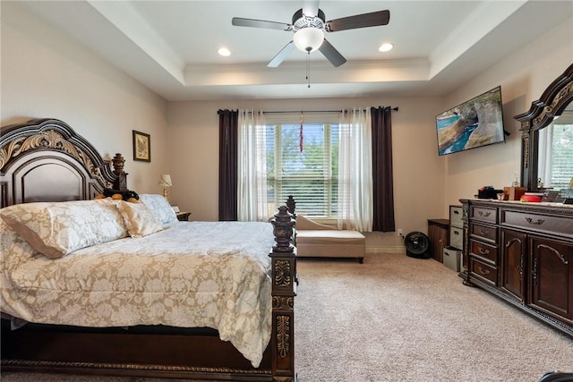 bedroom featuring a raised ceiling, multiple windows, ceiling fan, and carpet