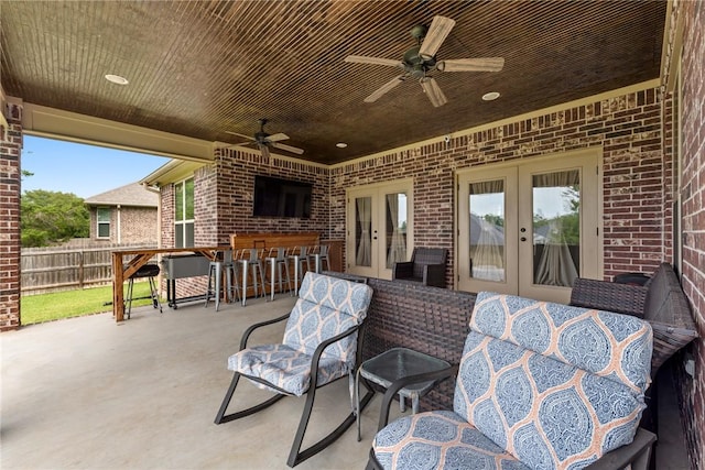 view of patio / terrace with a bar, french doors, and ceiling fan