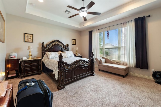 carpeted bedroom with a tray ceiling and ceiling fan