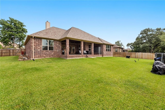 rear view of house with a yard