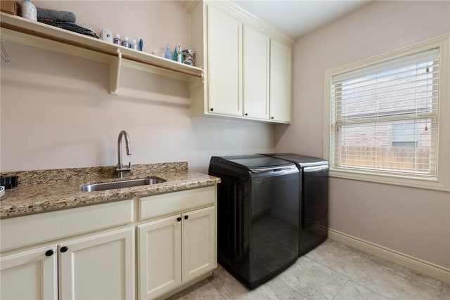 laundry room featuring washer and dryer, light tile patterned floors, cabinets, and sink