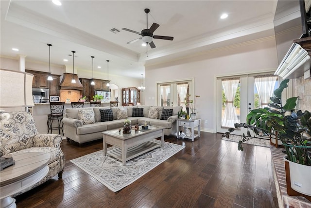 living room featuring a tray ceiling, dark hardwood / wood-style flooring, and french doors