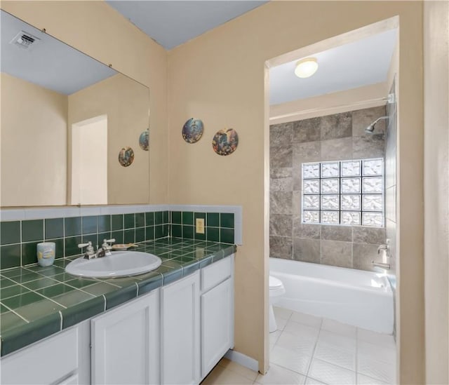 full bathroom with tile patterned flooring, backsplash, vanity, toilet, and tiled shower / bath