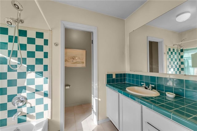 bathroom with tasteful backsplash, vanity, tile patterned flooring, and tiled shower / bath