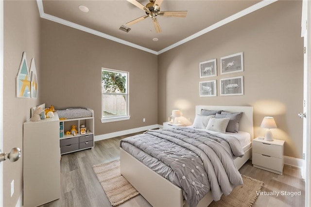 bedroom with ornamental molding, ceiling fan, and light hardwood / wood-style floors