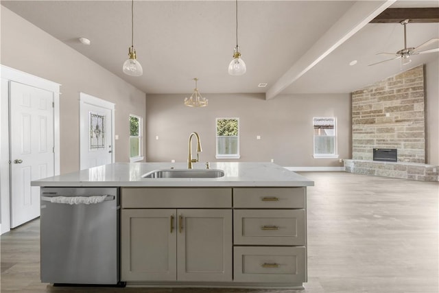 kitchen featuring gray cabinets, dishwasher, sink, and a center island with sink