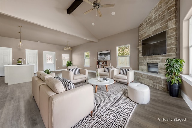 living room with hardwood / wood-style flooring, ceiling fan, lofted ceiling with beams, and a brick fireplace