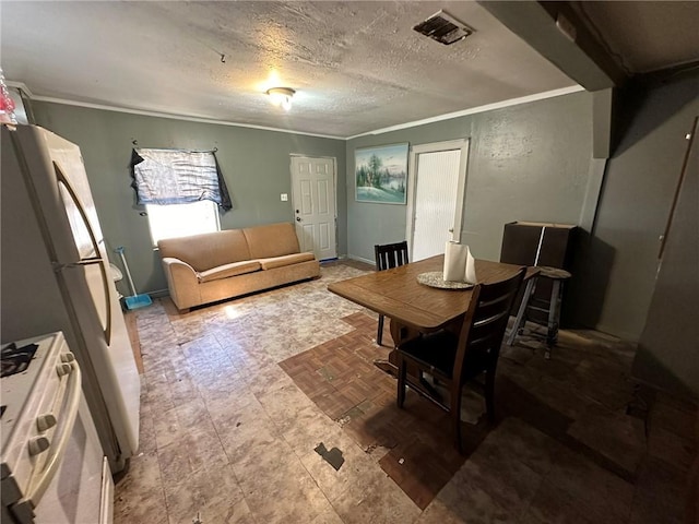 dining space featuring a textured ceiling and ornamental molding