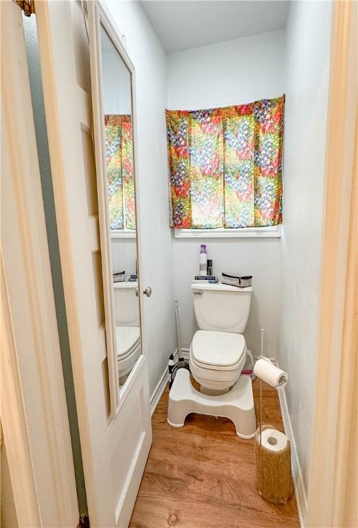 403N Banks St, Caldwell, TX 77836 - bathroom featuring toilet, wood finished floors, and baseboards