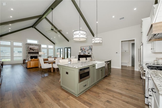 kitchen featuring visible vents, ceiling fan, open floor plan, appliances with stainless steel finishes, and a sink