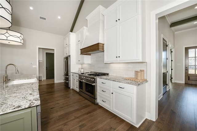 kitchen with visible vents, premium range hood, premium appliances, a sink, and tasteful backsplash