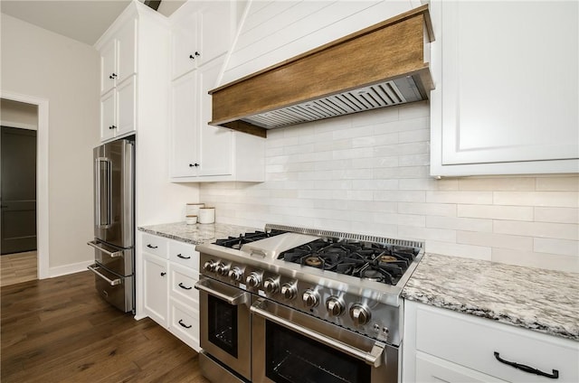 kitchen with premium range hood, dark wood-style flooring, white cabinetry, high quality appliances, and backsplash