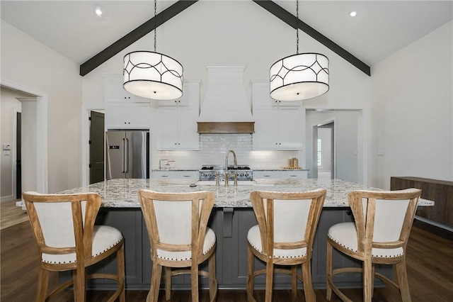 kitchen with high end fridge, custom range hood, tasteful backsplash, white cabinets, and dark wood-style flooring