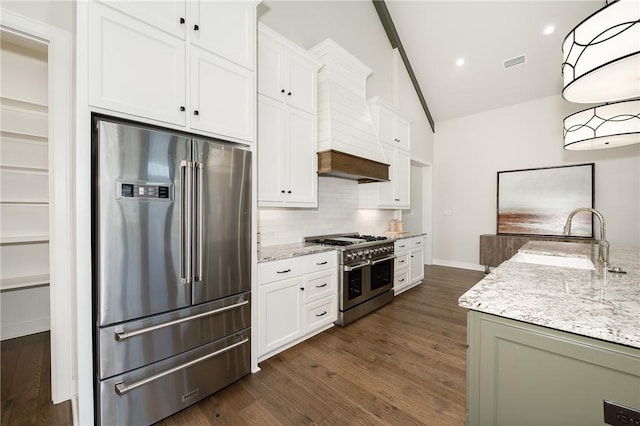 kitchen with light stone counters, visible vents, stainless steel appliances, and a sink