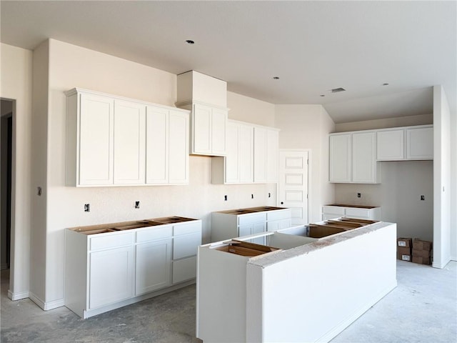 3108 Charge Ln, Bryan, TX 77808 - kitchen with a kitchen island, white cabinets, and concrete flooring