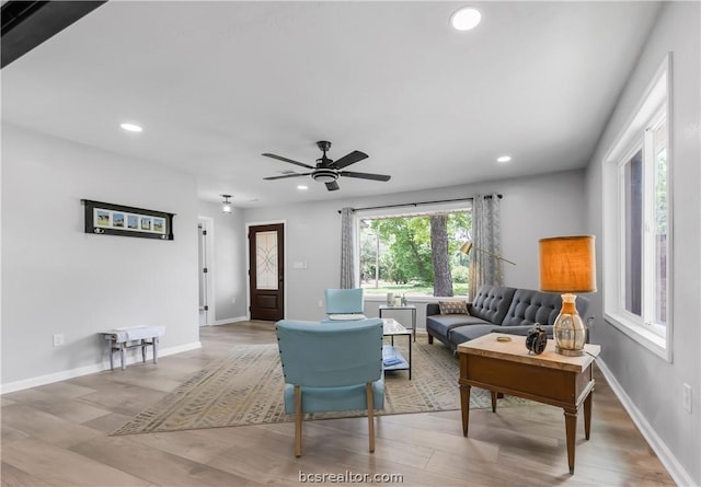 living room featuring ceiling fan and light hardwood / wood-style floors