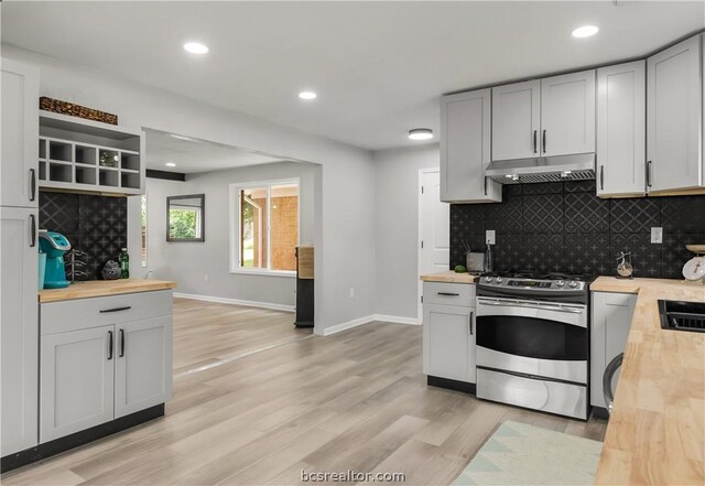 kitchen featuring backsplash, light hardwood / wood-style flooring, butcher block counters, and stainless steel range oven