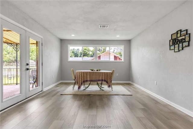 home office with french doors and light hardwood / wood-style flooring