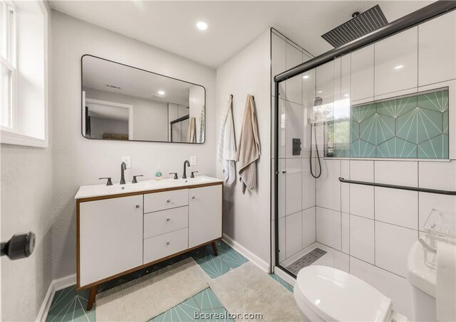 bathroom with tile patterned floors, vanity, toilet, and a shower with shower door