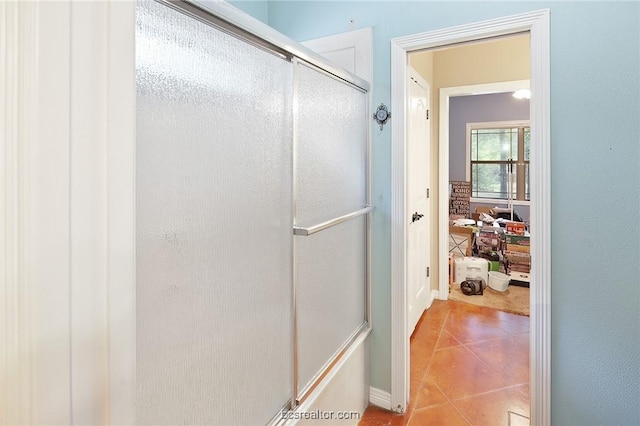 bathroom featuring tile patterned floors and a shower with shower door