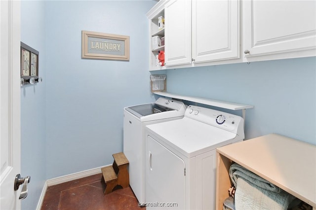 laundry room featuring separate washer and dryer and cabinets