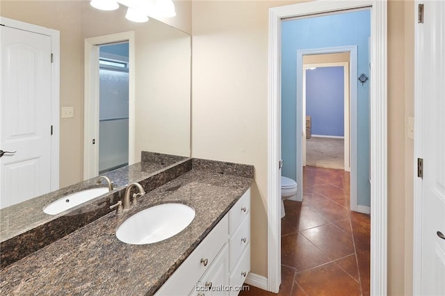 bathroom featuring vanity, tile patterned floors, and toilet