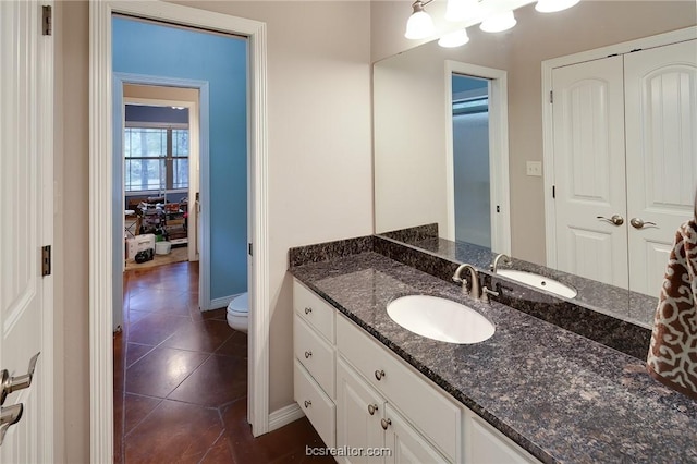 bathroom with tile patterned flooring, vanity, and toilet