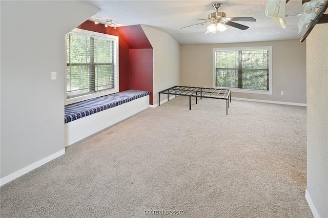 rec room with ceiling fan, vaulted ceiling, carpet, and a textured ceiling