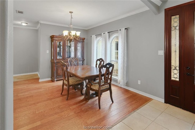 dining room featuring light hardwood / wood-style flooring, an inviting chandelier, and ornamental molding